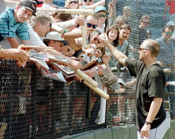 Baltimore Orioles shortstop Cal Ripken (R) hands a ball back after signing it as he is besieged by autograph-seeking fans following the Orioles practice. (Rhona Wise /AFP via Getty Images)