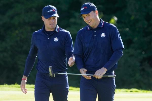 Team USA's Justin Thomas and Jordan Spieth react as they walk off the ninth green during a foursomes match at the Ryder Cup at the Whistling Straits Golf Course in Sheboygan, Wis., on Sept. 25, 2021. (Charlie Neibergall/AP Photo)