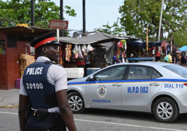 A Jamaica Constabulary Force police officer stands guard in the Half Way Tree neighbourhood in Kingston, Jamaica, on May 18, 2019. (Angela Weiss/AFP via Getty Images)