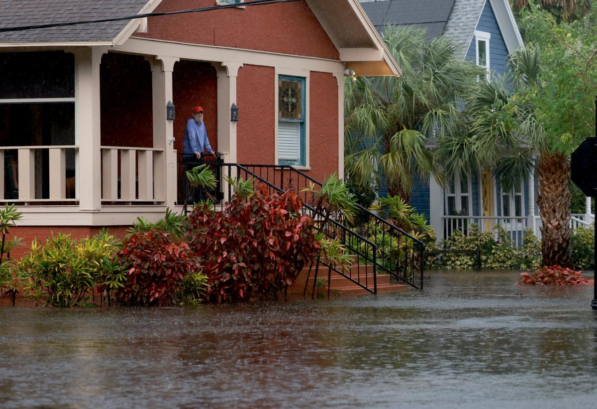Steve Odom stands on the porch of his home in Tarpon Springs, Fla., on August 30, 2023, which was still surrounded by flood waters caused by Hurricane Idalia passing offshore the night before. (Photo by Joe Raedle/Getty Images)