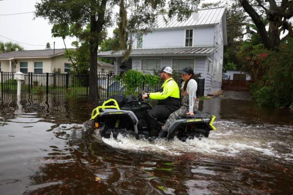 People ride an ATV through streets flooded by Hurricane Idalia passing offshore in Tarpon Springs, Fla., on August 30, 2023. (Joe Raedle/Getty Images)