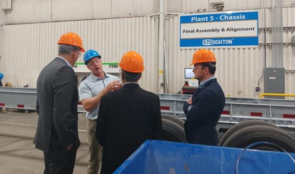 Reps. Darin LaHood (R-Ill.), Mike Gallagher (R-Wis.), and Raja Krishnamoorthi (D-Ill.) listen to Stoughton Trailers' Bob Wahlin during a tour of a chassis production line at the company's facility in Stoughton, Wis., on Aug. 30, 2023. (Nathan Worcester/The Epoch Times)