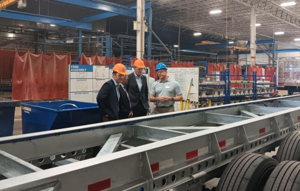 Rep. Darin LaHood (R-Ill.), Rep. Mike Gallagher (R-Wis.), and Rep. Raja Krishnamoorthi (D-Ill.) listen to Stoughton Trailers CEO Bob Wahlin during a tour of a chassis production line at the company's facility in Stoughton, Wis., on Aug. 30, 2023. (Nathan Worcester/The Epoch Times)