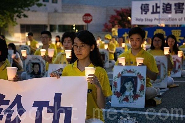 Cathy Wang (first from left) participated in a candlelight memorial service for Falun Gong practitioners in front of the Chinese Communist Party's embassy in the United States. (Lynn Lin / The Epoch Times)