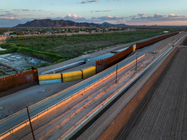Shipping containers fill a previous gap in the U.S.–Mexico border wall in Yuma, Arizona, on Sept. 27, 2022. Some gaps in the wall built by the Trump administration were filled with shipping containers by the Arizona state government in order to make it more difficult for immigrants to cross in certain areas. (John Moore/Getty Images)