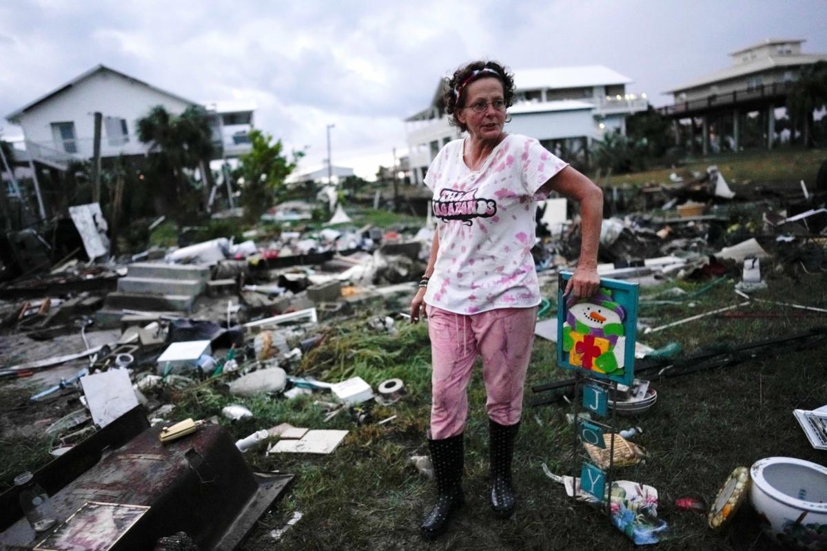 Jewell Baggett stands beside a Christmas decoration she recovered from the wreckage of her mother’s home, as she searches for anything salvageable from the trailer home in Horseshoe Beach, Fla., after the passage of Hurricane Idalia, on Aug. 30, 2023. (Rebecca Blackwell/AP Photo)