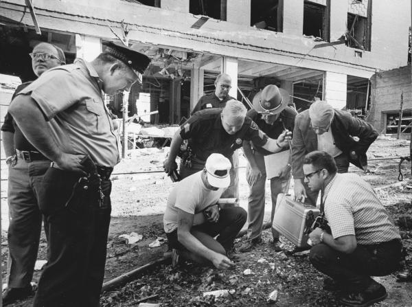 Officials look for clues after a bomb exploded outside the Army Mathematics Research Center in Sterling Hall at the University of Wisconsin in Madison, Wis., in August 1970. (Ed Stein/Wisconsin State Journal via AP)