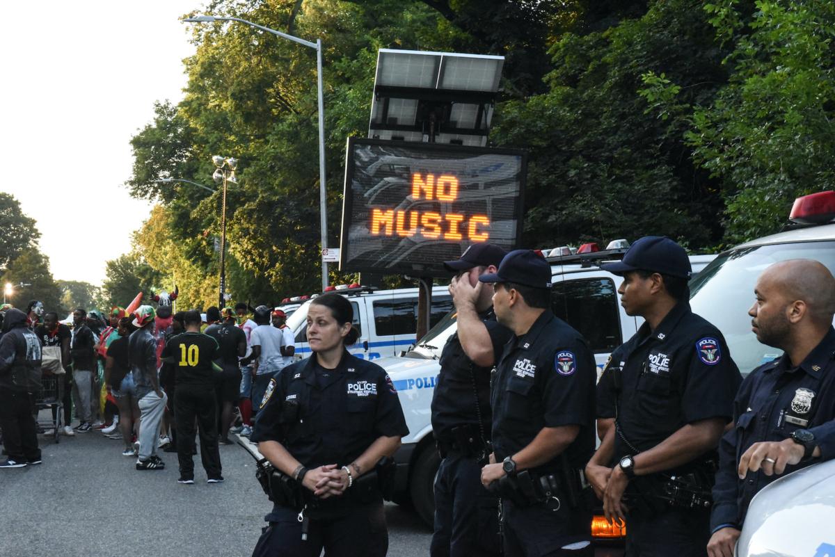 A police sign reads "no music" along the route of a Caribbean street carnival called J'ouvert in the Brooklyn borough of New York City on Sept. 4, 2017. J'Ouvert, which draws tens of thousands of costumed celebrants, has been plagued by violence in recent years, resulting in new intensive security measures. (Stephanie Keith/Getty Images)