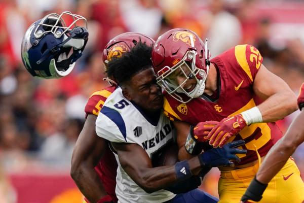 Nevada wide receiver Dalevon Campbell (5) loses his helmet after being hit by Southern California linebacker Tackett Curtis (25) during the first half of an NCAA college football game. Upon review by officials, Curtis was ejected on a targeting penalty, in Los Angeles on Sept. 2, 2023, (AP Photo/Ryan Sun)