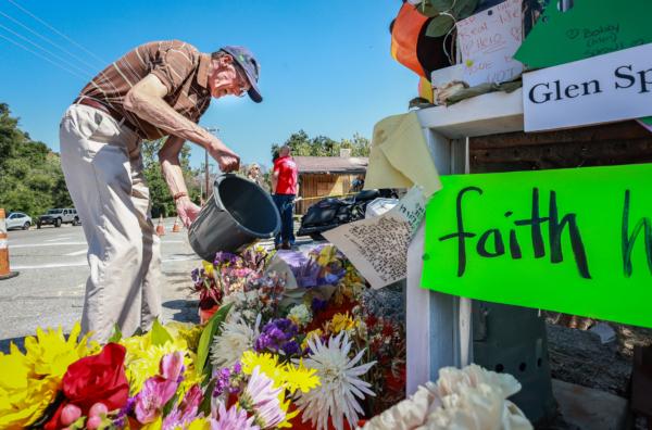 A man waters flowers at a memorial site set up for victims of a recent mass shooting at Cook's Corner restaurant and bar in Trabuco Canyon, Calif., on Sept. 1, 2023. (John Fredricks/The Epoch Times)