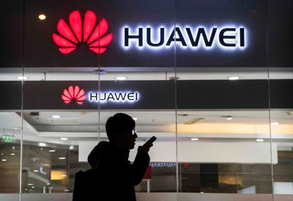 A pedestrian talks on the phone while walking past a Huawei Technologies Co. store in Beijing, China, on Jan. 29, 2019. (Kevin Frayer/Getty Images)