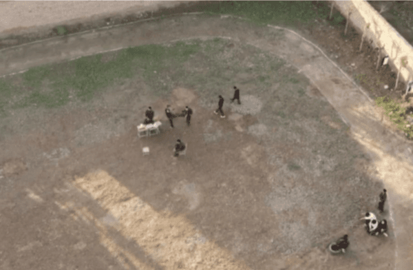 In this picture taken by Zhu Xinhai using a drone above the correctional school at the Xi’an Youth Military Training Youth Education Base around November 2020, the drillmaster is kicking a student’s stomach. (Zhu Xinhai)