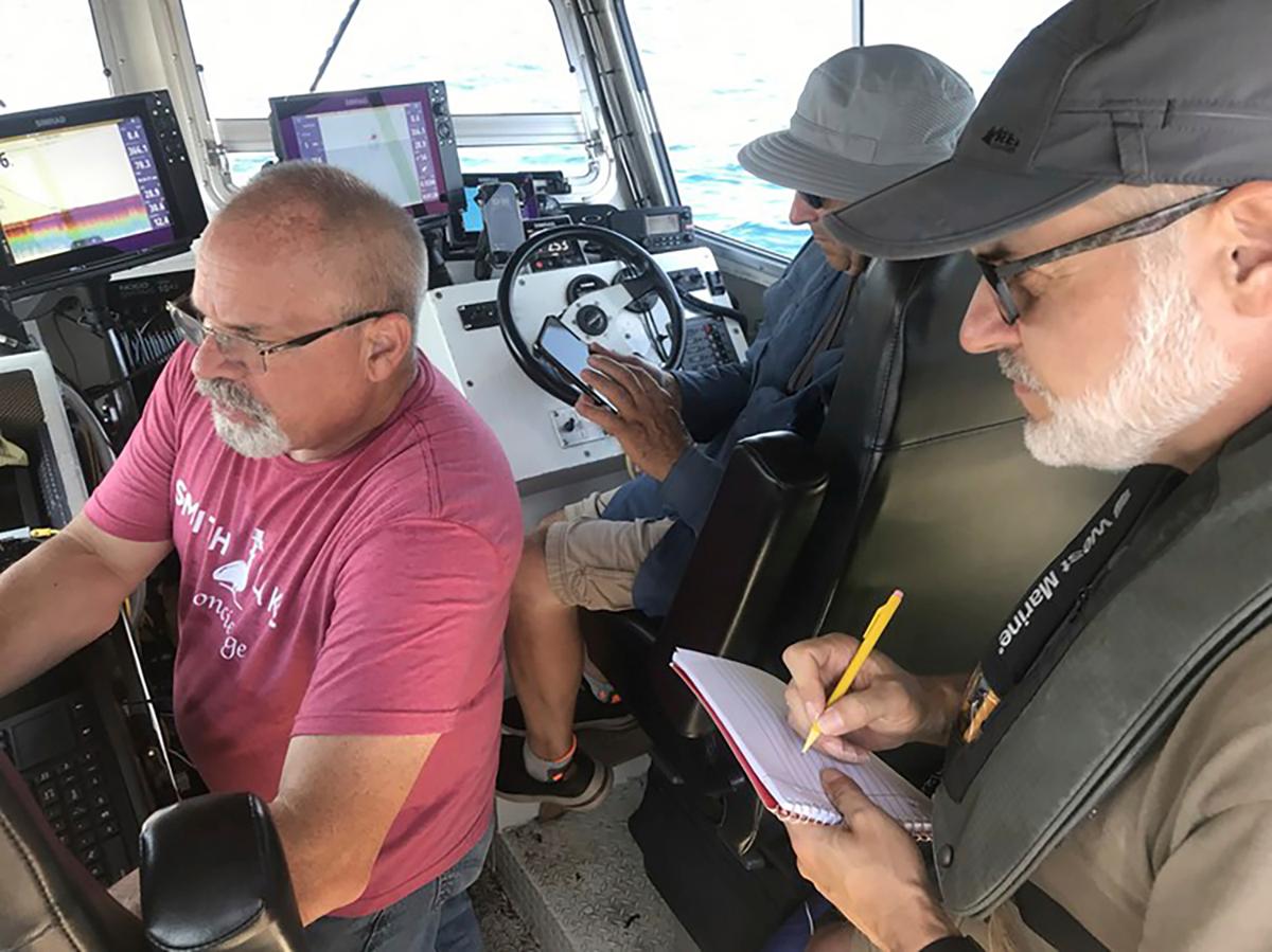 Brendon Baillod, Bob Jaeck, and Tom Crossmon survey the Trinidad off Algoma, Wis. Baillod and Jaeck found the 156-year-old Trinidad in July 2023 off Algoma at a depth of about 270 feet (82 meters). (Tamara Thomsen via AP)