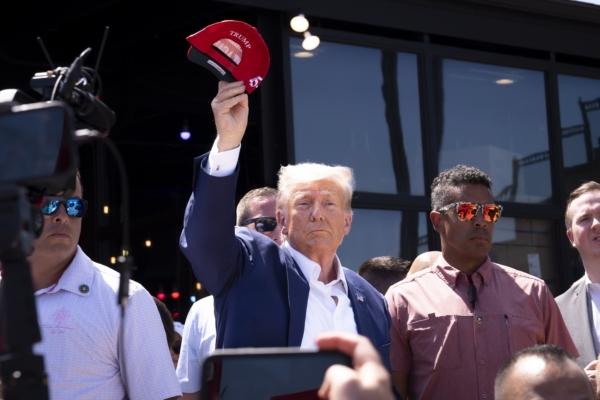 Former President Donald Trump tosses caps to the crowd at the Iowa State Fair in Des Moines, Iowa, on Aug. 12, 2023. (Madalina Vasiliu/The Epoch Times)