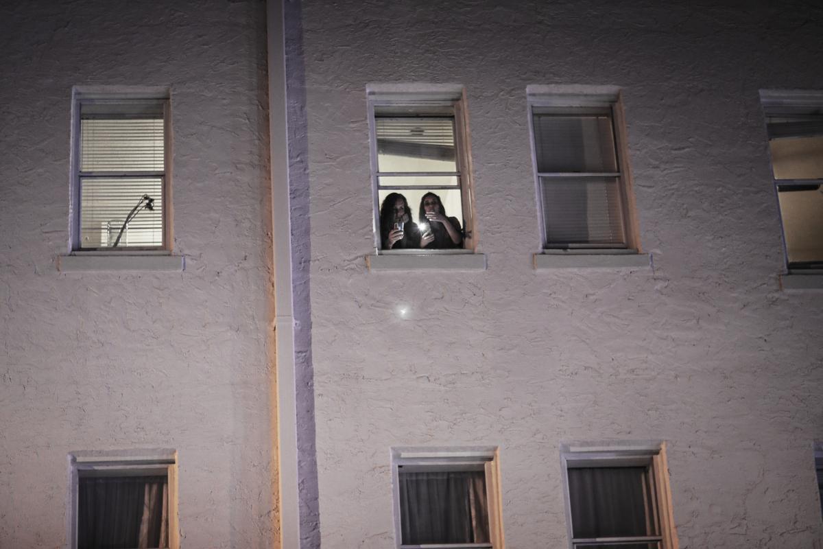 People watch from their apartments as Miami Beach police officers direct people away from the area as an 8pm curfew is in place on March 21, 2021 in Miami Beach, Florida. (Joe Raedle/Getty Images)