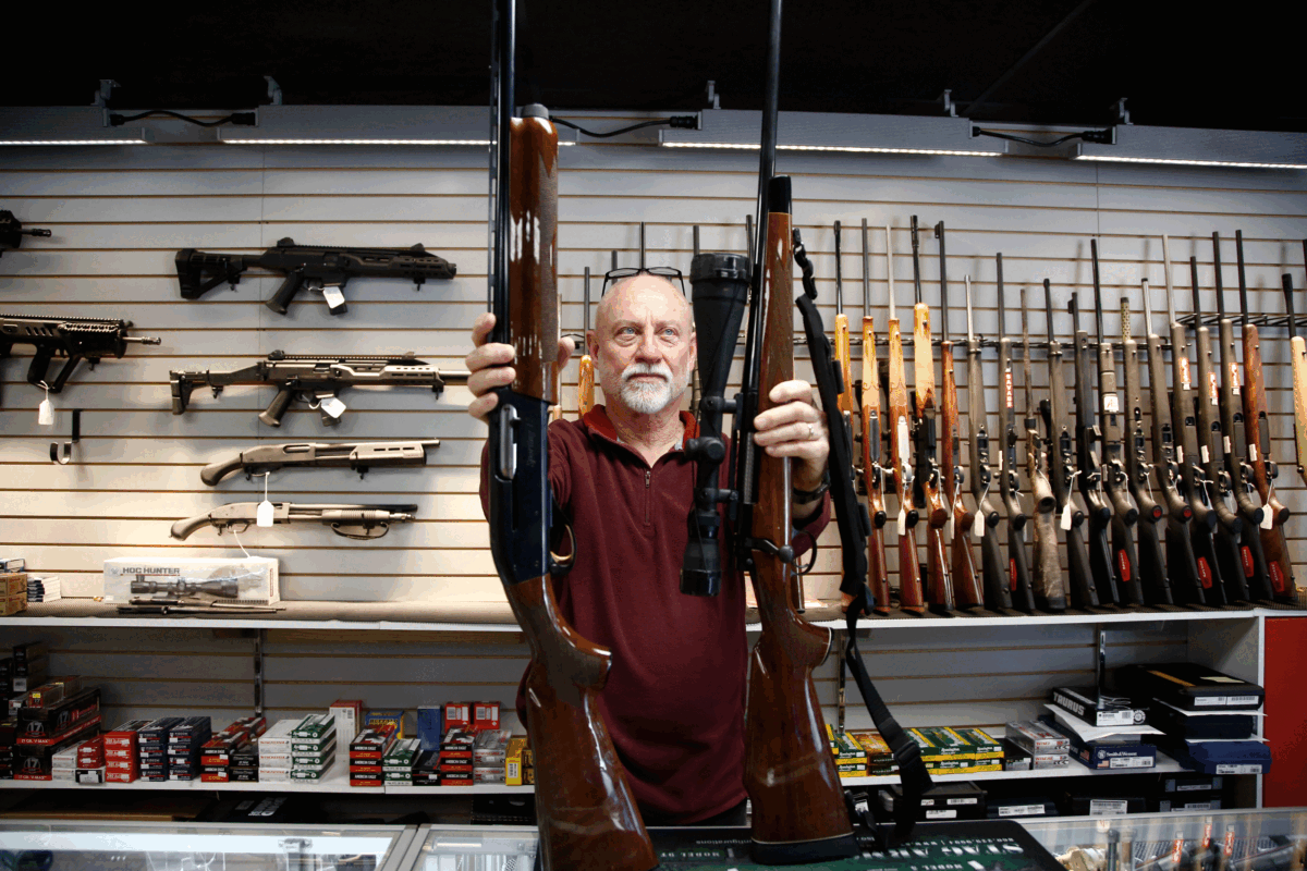 A man shows a Remington 700 hunting rifle and a Remington 1100 shotgun available for sale at Atlantic Outdoors gun shop in Stokesdale, N.C., on March 26, 2018. (Brian Blanco/Getty Images)