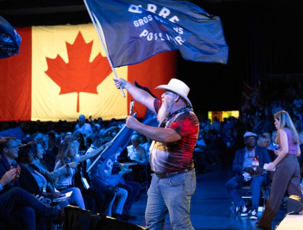A Conservative delegate calls on the crowd to cheer prior to Pierre Poilievre's speech at the Conservative Party Convention in Quebec City on Sept. 8, 2023. (The Canadian Press/Jacques Boissinot)