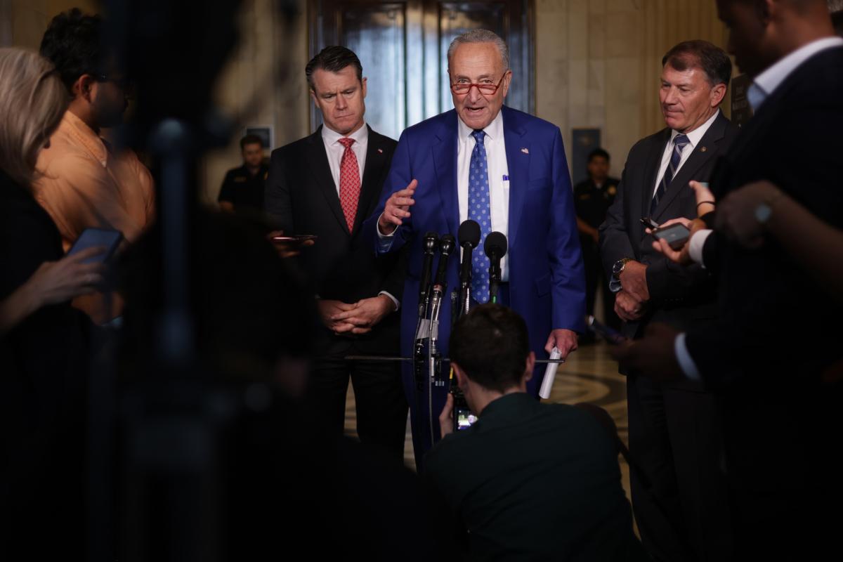 Senate Majority Leader Sen. Chuck Schumer (D-N.Y.) speaks to members of the press as Sen. Todd Young (R-Ind.), left, and Sen. Michael Rounds (R-S.D.), right, listen outside the “AI Insight Forum” on Capitol Hill in Washington on Sept. 13, 2023. (Alex Wong/Getty Images)
