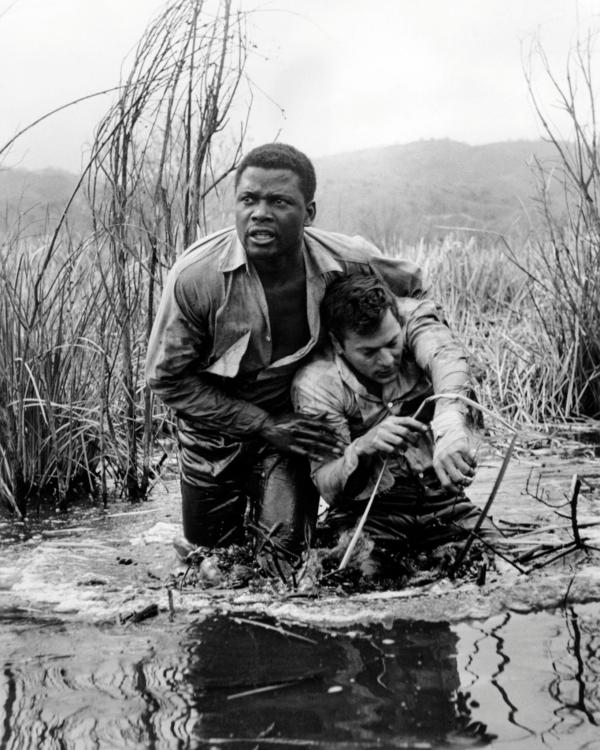 Noah Cullen (Sidney Poitier, L) and John “Joker” Jackson (Tony Curtis) hide in a swamp, in “The Defiant Ones.” (MovieStillsDB)