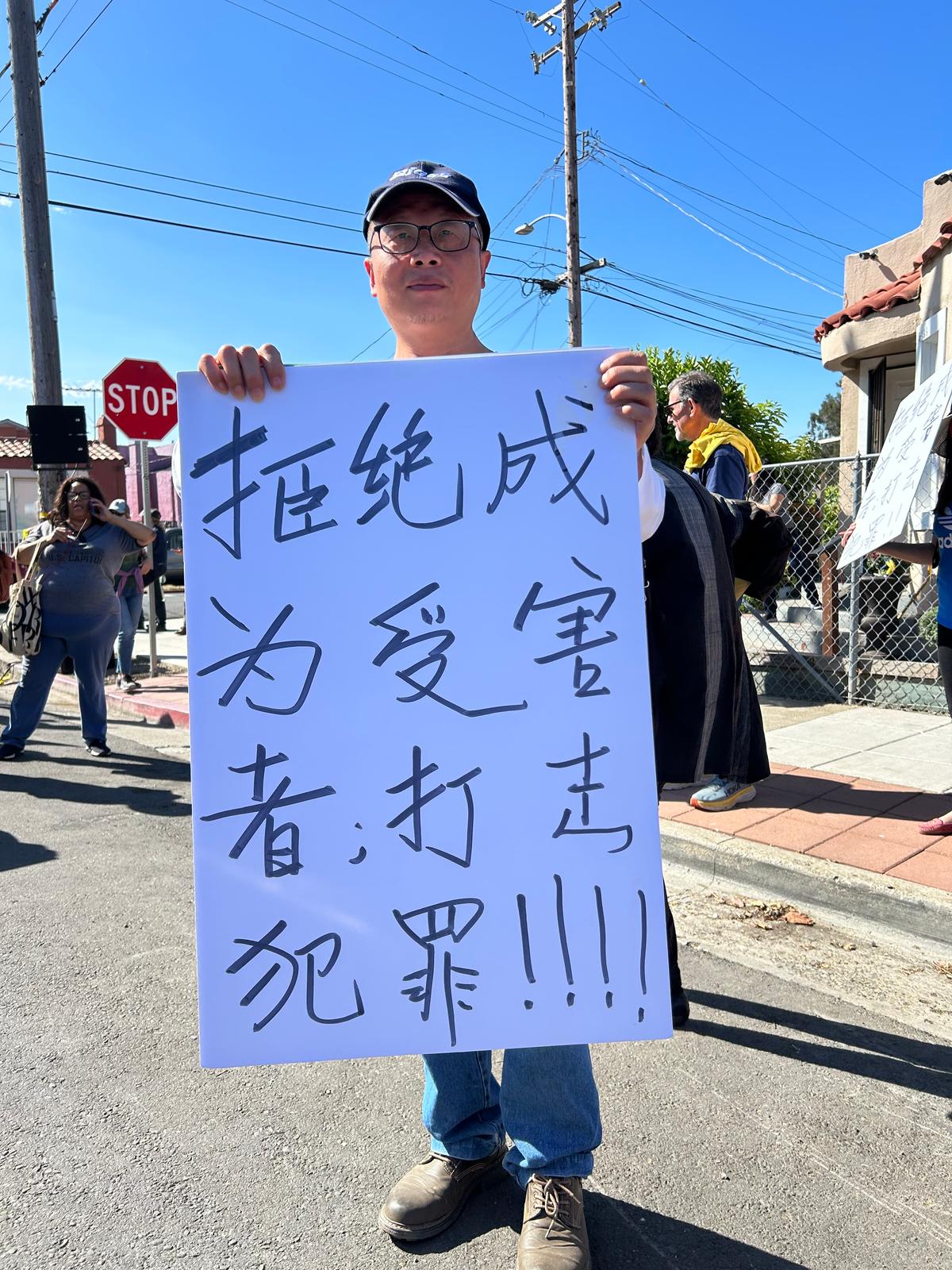 A man holds a sign in Chinese as locals concerned about public safety issues gather outside of a "Community Safety" meeting attended by local government and law enforcement officials at the Genesis Worship Center in East Oakland, Calif., on Sept. 9, 2023. (Courtesy of Loretta Breuning)