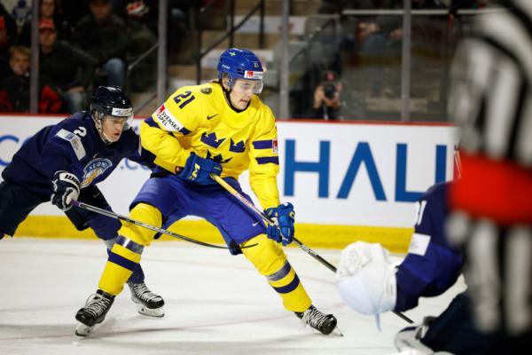 Leo Carlsson (21) of Team Sweden skates the puck to the net with Jimi Suomi (2) of Team Finland defending in the third period of a Quarterfinal game during the 2023 IIHF World Junior Championship at Avenir Centre in Moncton, Canada, on Jan. 2, 2023. (Dale Preston/Getty Images)