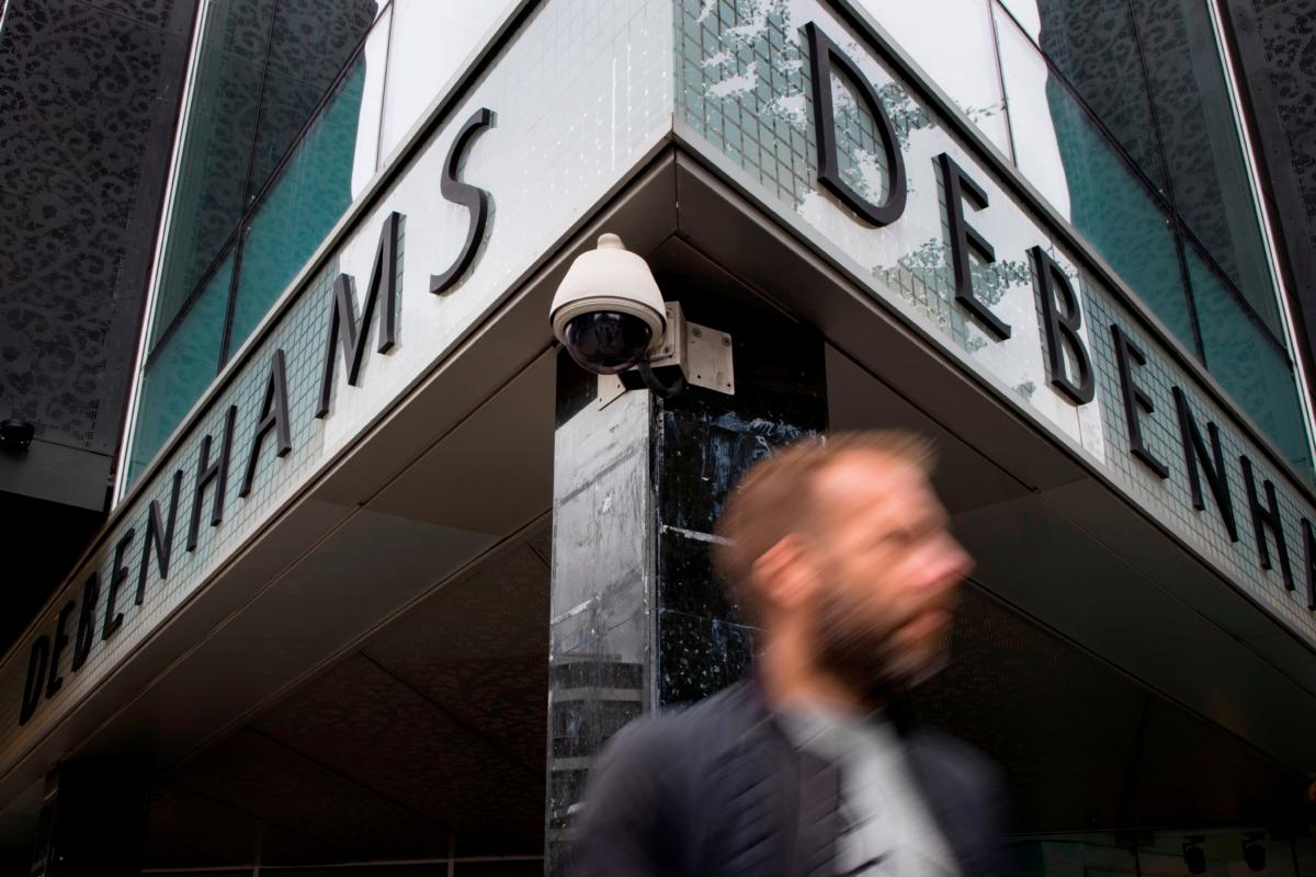 People walk past a CCTV camera operating on Oxford Street outside a Debenhams store in London on Aug. 16, 2019. (Tolga Akmen/AFP via Getty Images)