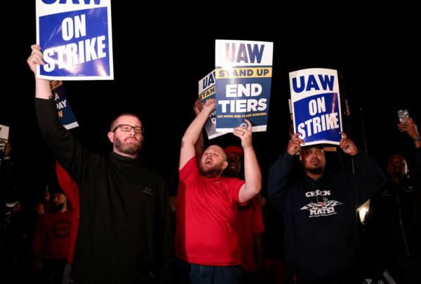 United Auto Workers hold up strike signs right across from the Ford Michigan Assembly Plant in Wayne, Mich., on Sept. 15, 2023. (Reuters/Rebecca Cook)