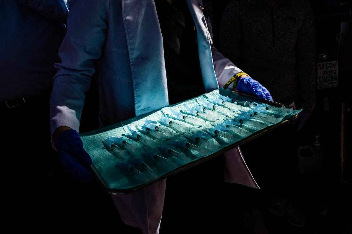 A medical assistant holds a tray of syringes filled with doses of Moderna COVID-19 vaccine at a vaccination site in Los Angeles on Feb. 16, 2021. (Apu Gomes/AFP via Getty Images)