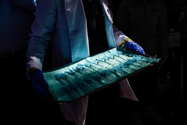  A medical assistant holds a tray of syringes filled with doses of Moderna COVID-19 vaccine at a vaccination site in Los Angeles, on Feb. 16, 2021. (Apu Gomes/AFP via Getty Images)