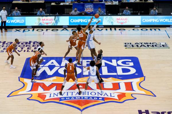 Texas forward Jericho Sims (20) and North Carolina forward Armando Bacot (5) tip off for the start of an NCAA college basketball game for the championship of the Maui Invitational, in Asheville, N.C., on Dec. 2, 2020, (Kathy Kmonicek/AP Photo)