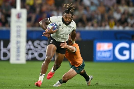 Fiji's outside centre and captain Waisea Nayacalevu (L) breaks through a tackle from Australia's centre Lalakai Foketi (R) as he runs with the ball during the France 2023 Rugby World Cup Pool C match between Australia and Fiji at Stade Geoffroy-Guichard in Saint-Etienne, south-eastern France on Sept. 17, 2023. (Olivier Chassignole/AFP via Getty Images)
