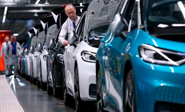 Employees work on electric cars on Feb. 25, 2020. (RONNY HARTMANN/AFP via Getty Images)