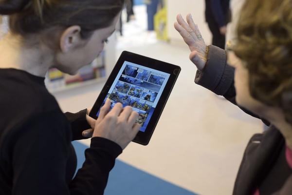 Visitors use an E-Book reader during the 35th edition of the Paris Book Fair on March 20, 2015. (Lionel Bonaventure/AFP via Getty Images)