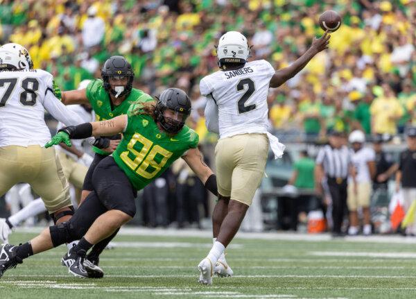 Shedeur Sanders (2) of the Colorado Buffaloes passes the ball against defensive lineman Casey Rogers (98) of the Oregon Ducks at Autzen Stadium in Eugene, Oregon, on Sept. 23, 2023. (Tom Hauck/Getty Images)