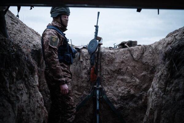 A member of a Ukrainian volunteer unit and a computer science student "Valdemar," 19, poses in a gun position used by the unit to counter threats during air-raid sirens in a suburb of Kyiv on Feb. 28, 2023. (Yasuyoshi Chiba/AFP via Getty Images)