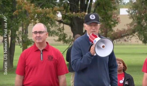 President Joe Biden (R), alongside UAW president Shawn Fain, addresses striking UAW workers in Wayne County, Mich., on Sept. 26, 2023. (US Network Pool via AP)