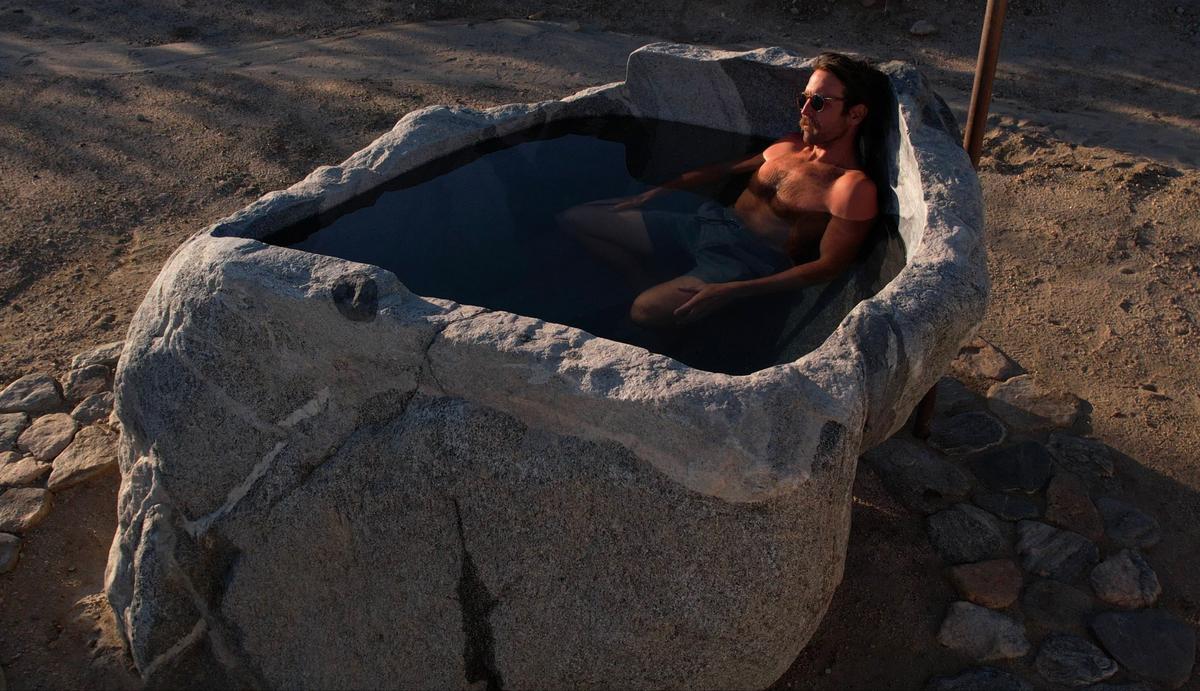 James Lostlen enjoys a mineral water bath and the view of Mount San Jacinto from his stone bathtub. (Courtesy of Paul Silva)