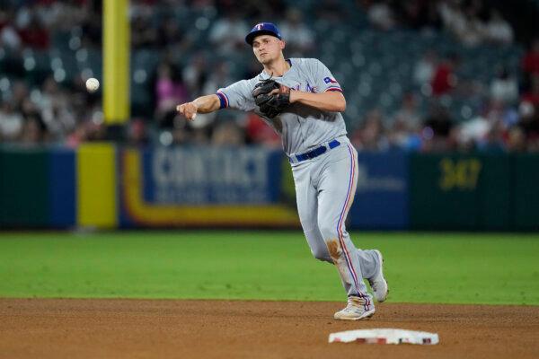 Texas Rangers shortstop Corey Seager (5) throws to first to out Los Angeles Angels' Brandon Drury during the third inning of a baseball game in Anaheim, Calif., on Sept. 26, 2023. (Ashley Landis/AP Photo)