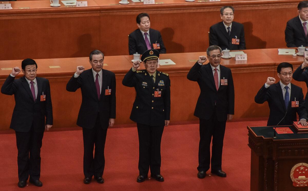 Newly elected state councilors (L-R) Zhao Kezhi, Wang Yi, and Wei Fenghe, Vice Premiers Hu Chunhua and Han Zheng, swear an oath during the seventh plenary session of the 13th National People's Congress (NPC) at the Great Hall of the People in Beijing, on March 19, 2018. (Etienne Oliveau/Getty Images)