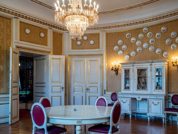 The elegant dining room dates from the time of Christian X and Queen Alexandrine, who lived in the palace from 1899 to 1947 and in 1952. Most of the furnishings, including the dining table and chairs, the cabinet, the chandelier, and the golden walls, are unchanged. The decorative plates on the wall were wedding presents for the royal couple and represent motifs from the town of Randers, Denmark. (Dr. Victor Yong/Shutterstock)