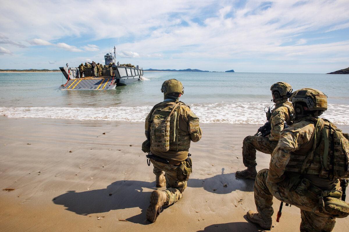 Australian Army soldiers from 10th Force Support Battalion's Amphibious Beaching Team await the arrival of troops on an Lighter Landing Craft during Exercise Trident 2022 near Shoalwater Bay Training Area, Queensland. (Australian Defence Force)