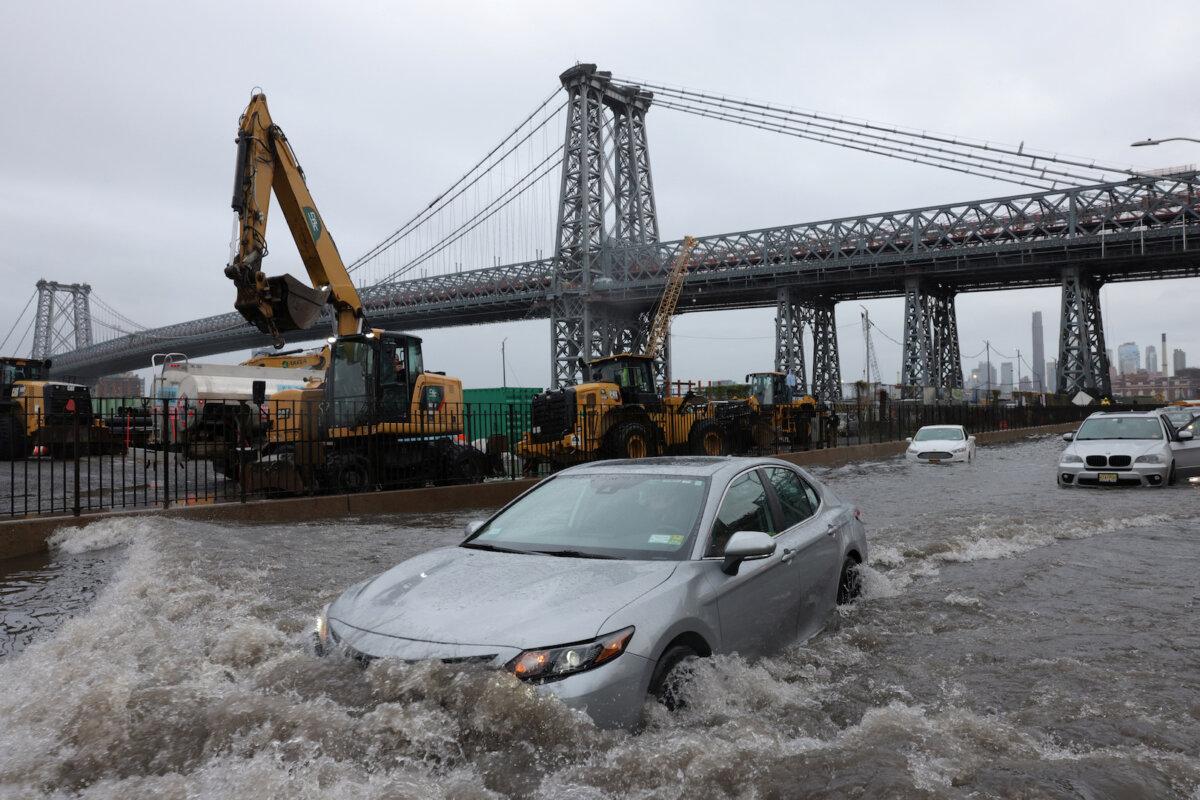 A motorist drives through a flooded street after heavy rains bring flooding across the mid-Atlantic and Northeast, at the FDR Drive in Manhattan near the Williamsburg Bridge, in New York City, on Sept. 29, 2023. (Andrew Kelly/Reuters)