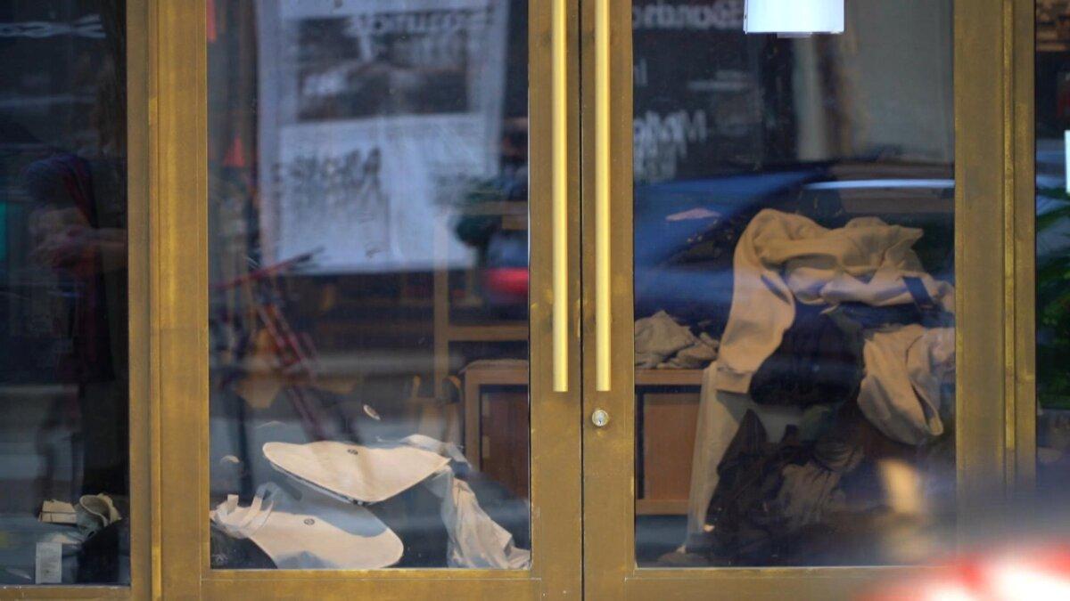 A mess of clothes on the floor of the Lululemon store seen through its front glass door on Sept. 27, 2023, a day after it was looted. (William Huang/The Epoch Times)