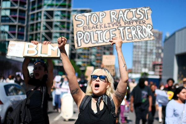 Demonstrators carry placards with slogans as they march to protest the death of George Floyd outside the U.S. Embassy in London on May 31, 2020. “Society tells you that being a conservative or a Republican makes you a racist,” says Mr. Dorr. (Daniel Leal/AFP via Getty Images)