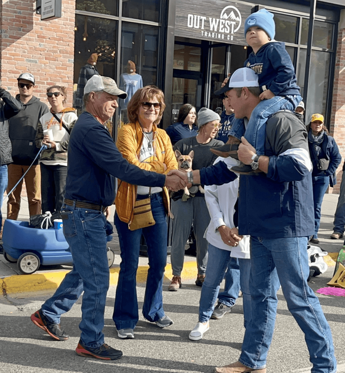 Montana Republican U.S. senate candidate, with his son, Walter, riding his shoulders, greets voters in Bozeman, Montana, during Montana State University’s Sept. 30 Homecoming parade. (Sheehy For Montana)