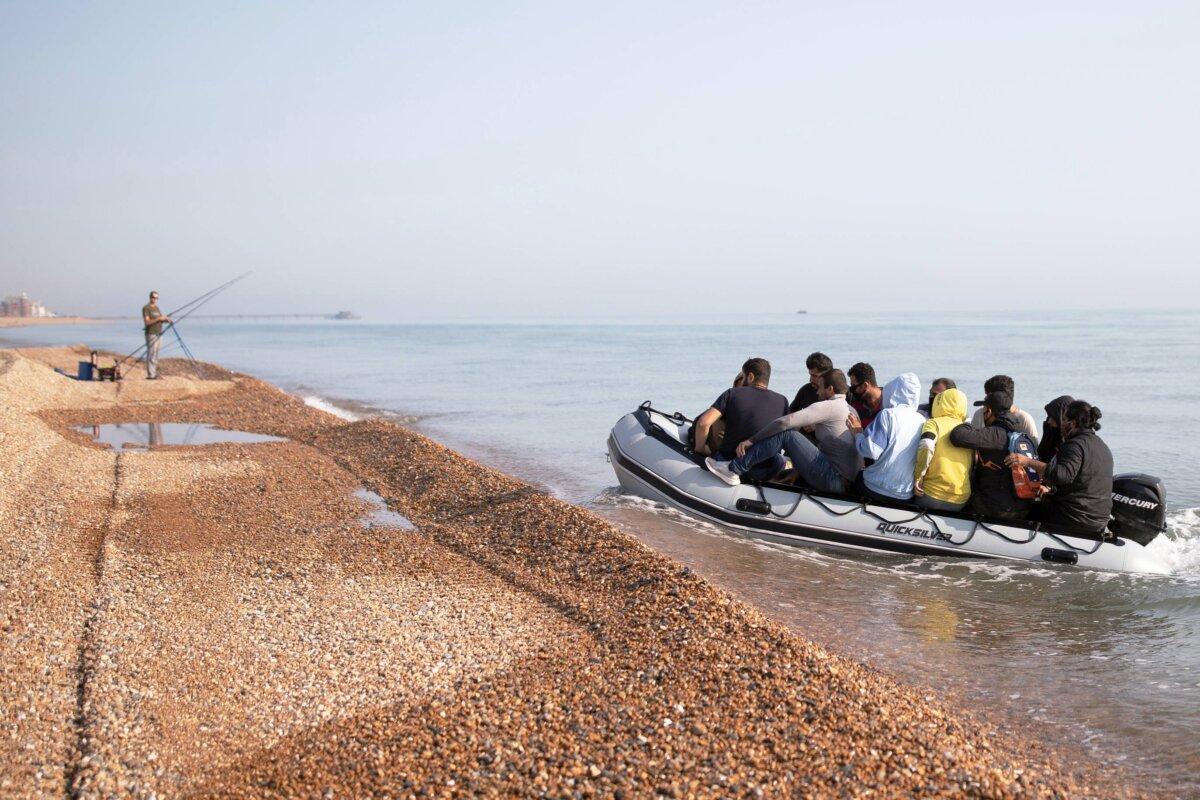 A fisherman watches as illegal immigrants land on Deal beach after crossing the English Channel from France in a dinghy, in Deal, England, on Sept. 14, 2020. (Luke Dray/Getty Images)