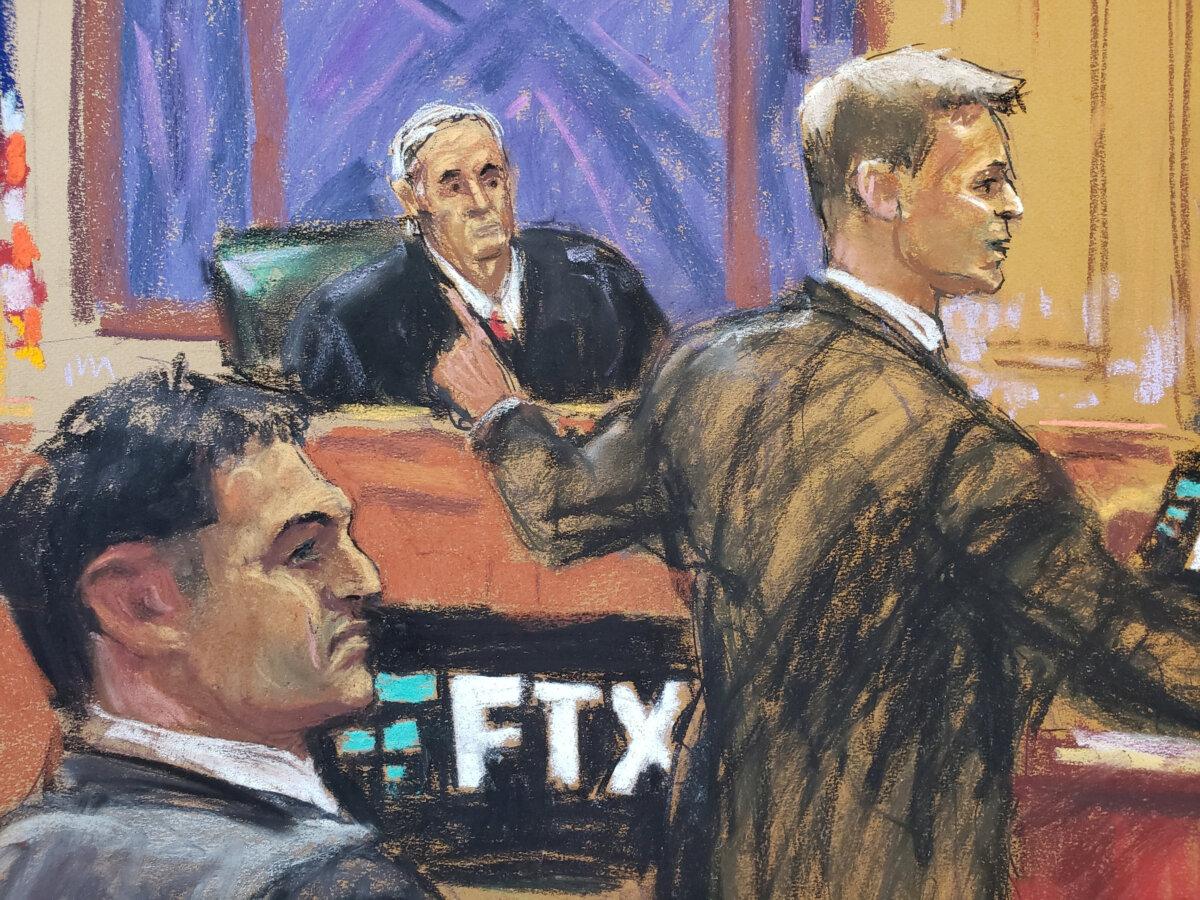 In this courtroom sketch, Sam Bankman-Fried watches as defense lawyer Mark Cohen makes his opening remark in Bankman-Fried's fraud trial at Federal Court in New York, on Oct. 4, 2023. (Jane Rosenberg/Reuters)