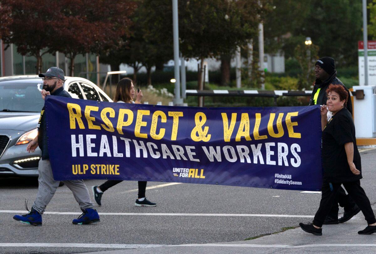 Kaiser Permanente workers carry a sign outside the hospital during a protest strike in the Panorama City section of Los Angeles on Oct. 4, 2023. (Richard Vogel/AP Photo)