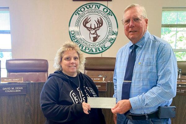 Town of Deerpark Supervisor Gary Spears (R) and his assistant, Danielle Glynn, hold a check they received from Dragon Springs, in Cuddebackville, N.Y., on Sept. 27, 2023. (Courtesy of Dragon Springs)