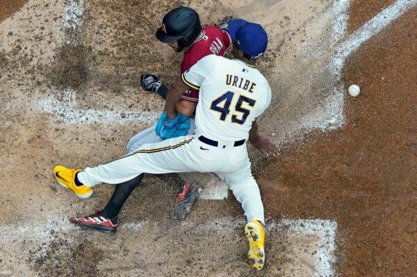 Arizona Diamondbacks' Tommy Pham scores past Milwaukee Brewers relief pitcher Abner Uribe during the sixth inning of a Game 2 of their National League wildcard baseball series in Milwaukee on Oct. 4, 2023. (Morry Gash/AP Photo)